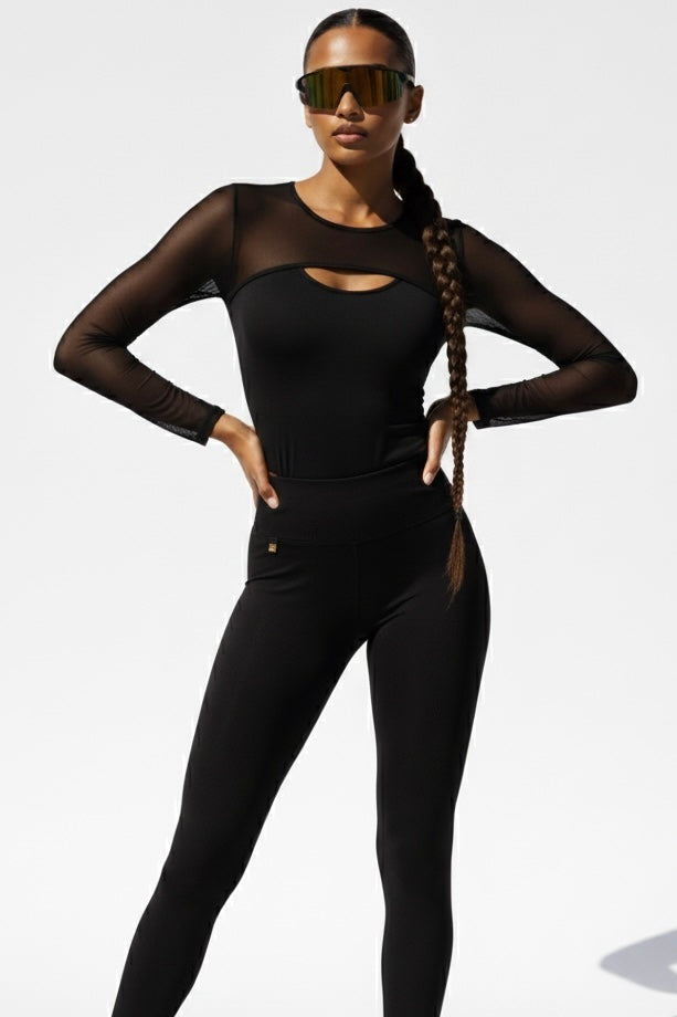 Das Mesh an Passe und Ärmeln ist durchsichtig, die Mitte blickdicht. Die Leggings haben ein kleines Goldlogo.