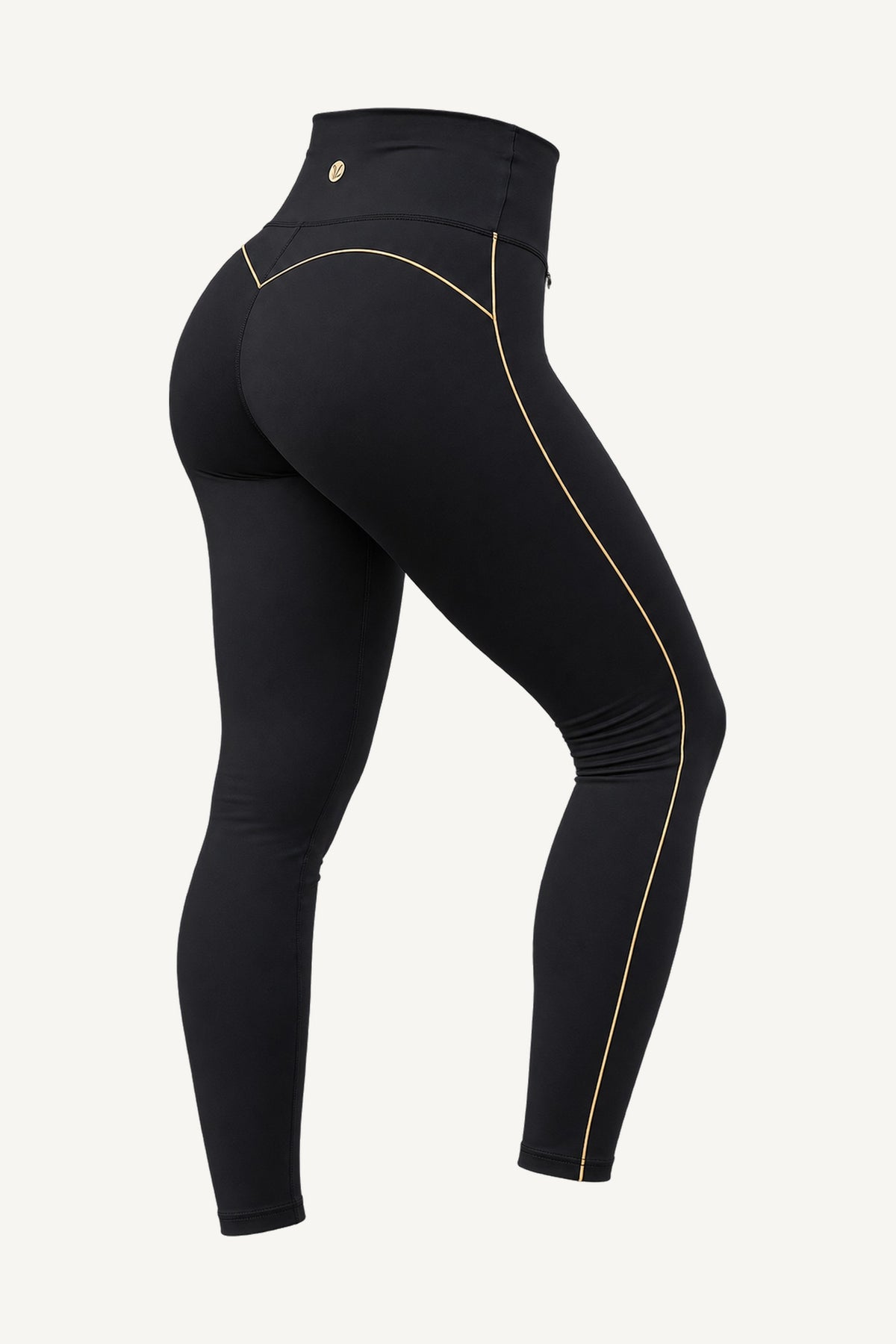 Slimline FlexFlow Träningstights Svart/Guld freigestellt, schräg von hinten. Eine einzige Goldlinie am Bein entlang und ein goldfarbenes Plättchen an der Taille.
