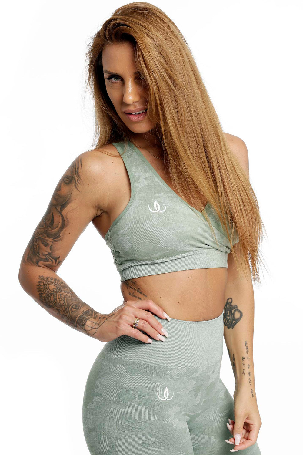 Weißes Logo auf dem mintgrünen Top, das eng über der Taille sitzt, Leggings im gleichen Muster.