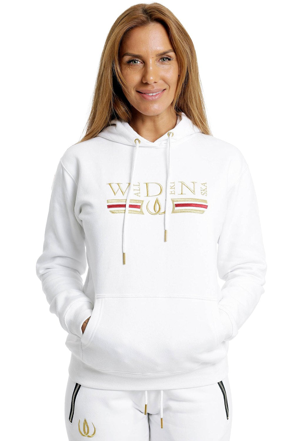 Deluxe Hoodie Weiß mit Goldstickerei und rotem Streifen über der Brust, getragen zu weißen Joggers.