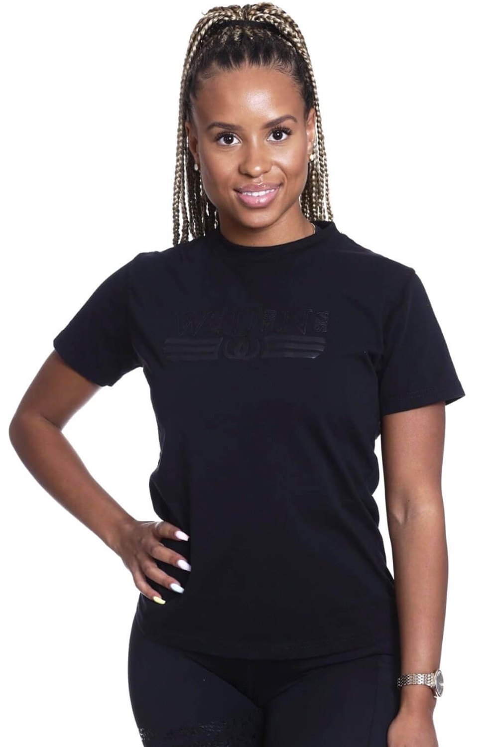 Das Model steht mit der Hand an der Hüfte im schwarzen Top mit Ton-in-Ton-Logo.