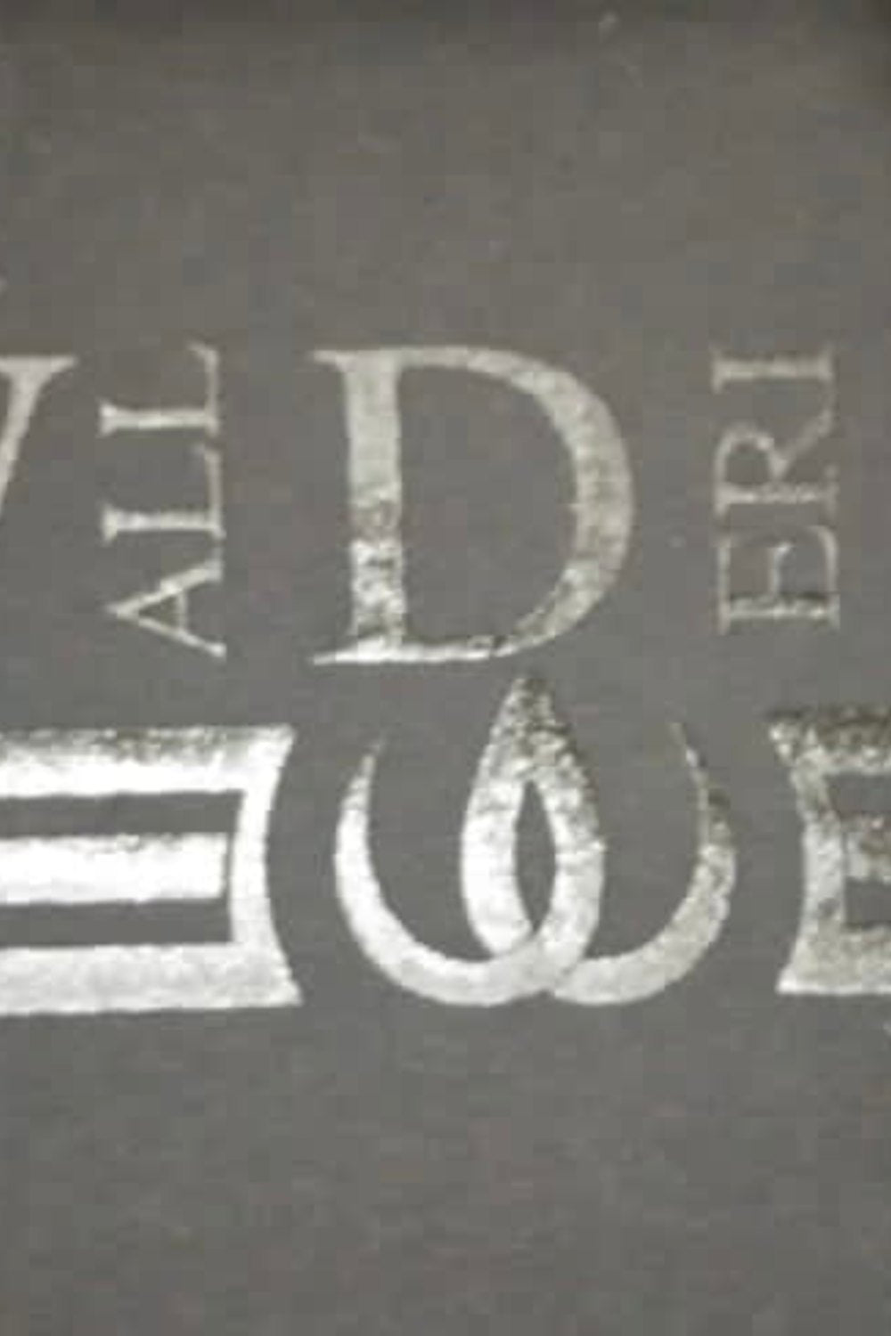 Das Logo, gedruckt im selben dunklen Ton wie der Stoff, mit Buchstaben und zwei Strichen um das Symbol.