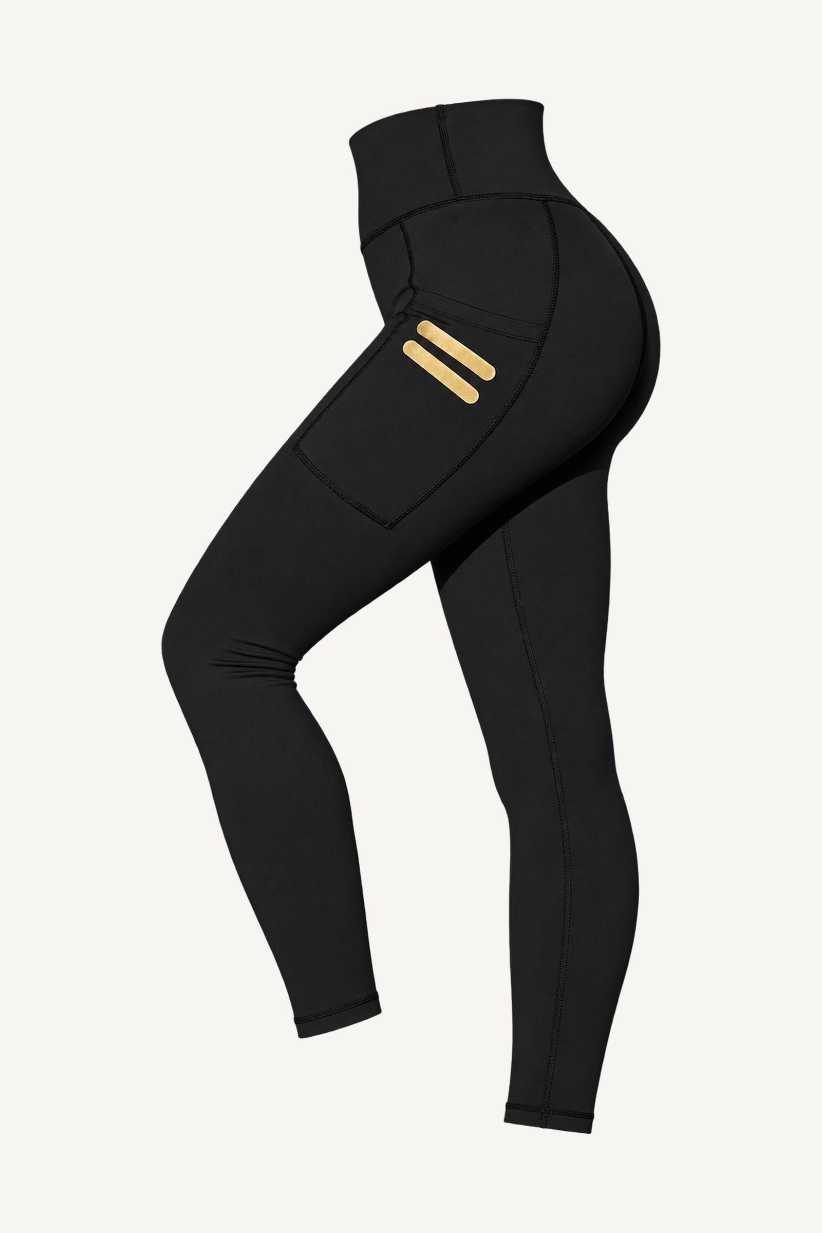 Iconic Stripe Tights Med Fickor freigestellt, schräg von vorne. Taschen an beiden Beinen mit zwei kurzen Goldstrichen.
