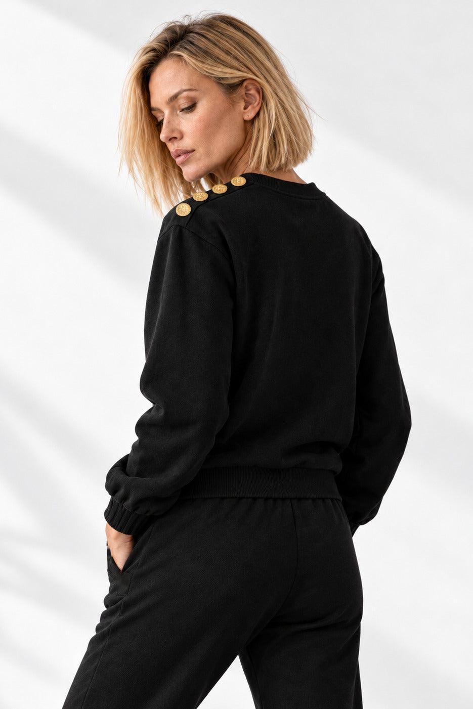 Edge Gold Button Pullover schräg von hinten, mit den Goldknöpfen entlang der Schulter.